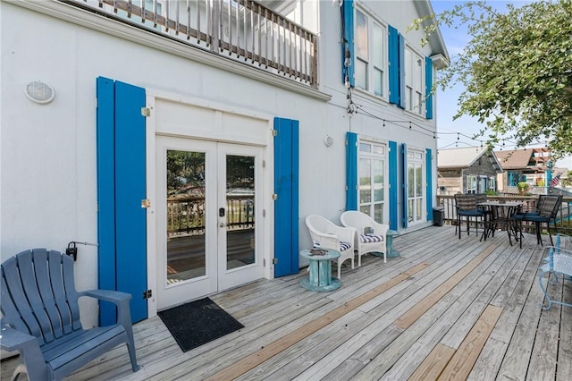 wooden terrace with french doors and outdoor dining area