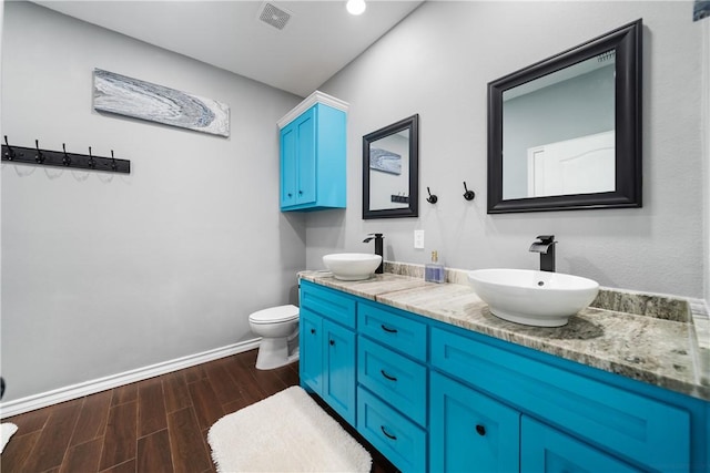230 Valerie St, Corpus Christi, TX 78418 - full bath with wood finished floors, double vanity, baseboards, and toilet