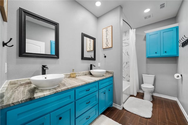 230 Valerie St, Corpus Christi, TX 78418 - bathroom with wood finished floors, double vanity, baseboards, toilet, and shower / tub combo with curtain