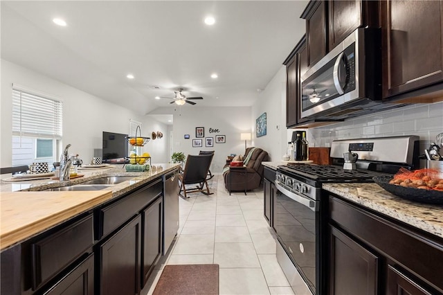 kitchen featuring light tile patterned flooring, sink, ceiling fan, stainless steel appliances, and backsplash