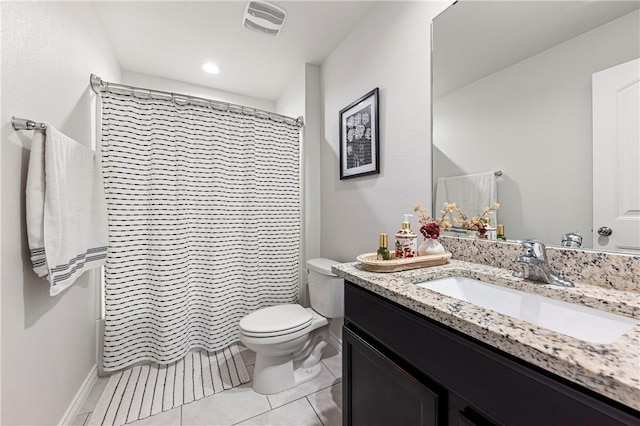 bathroom featuring walk in shower, vanity, toilet, and tile patterned flooring