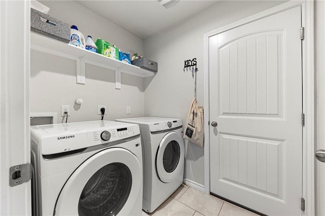 laundry room with light tile patterned flooring and washing machine and clothes dryer