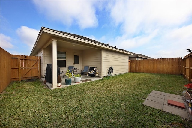 rear view of house with a yard and a patio