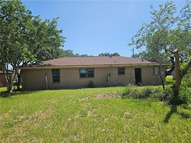 909 Johnson St, Woodsboro, TX 78393 - back of property featuring brick siding and a lawn