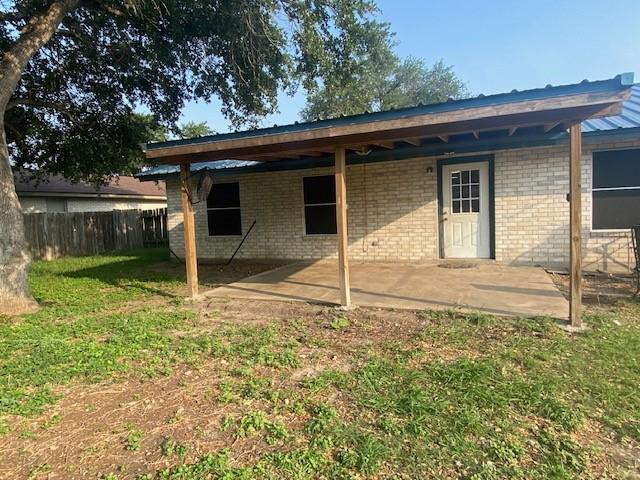 back of house with a patio area and brick siding