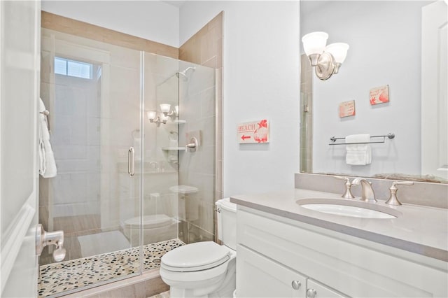 bathroom featuring a shower with door, vanity, and toilet