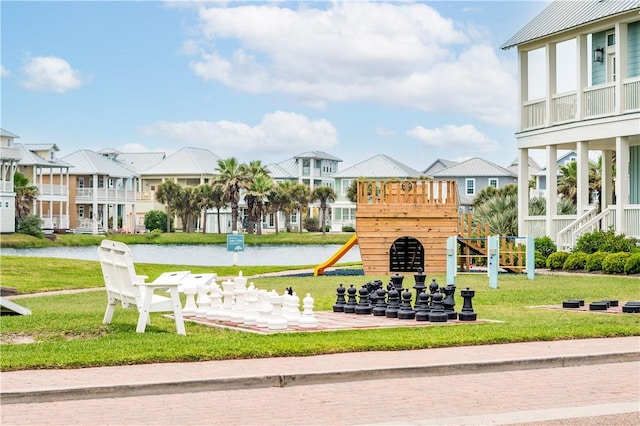 view of play area featuring a lawn and a water view