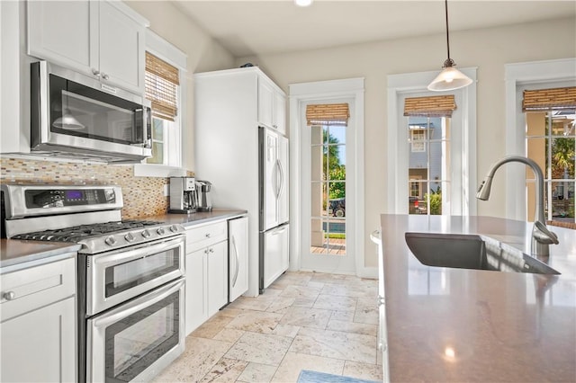 kitchen featuring a healthy amount of sunlight, sink, white cabinets, and stainless steel appliances