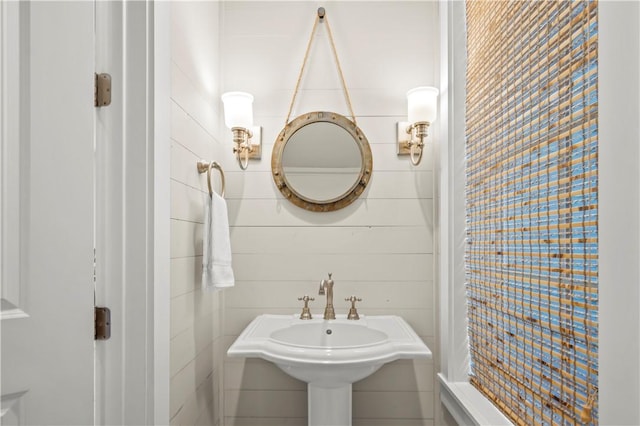 bathroom with sink and tile walls