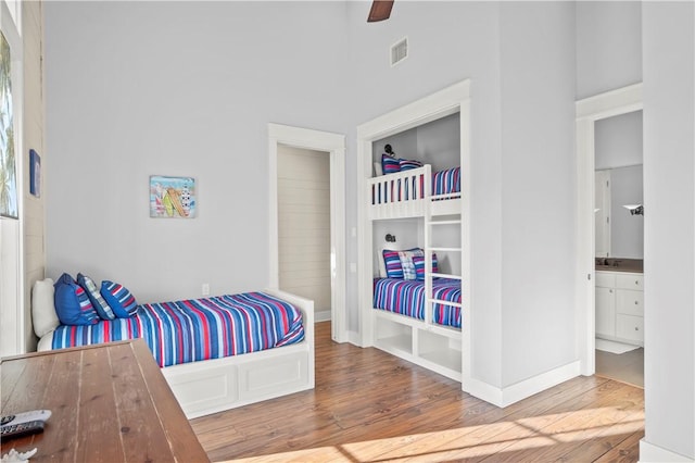 bedroom featuring hardwood / wood-style floors, ceiling fan, sink, and ensuite bathroom