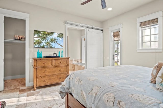 bedroom featuring ceiling fan and a barn door