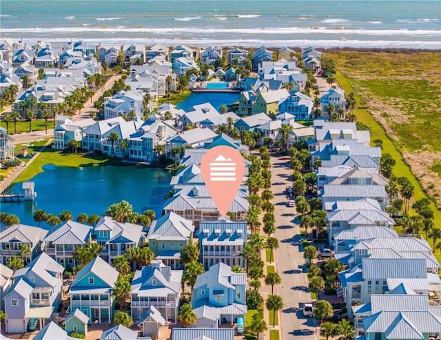 birds eye view of property with a water view and a view of the beach