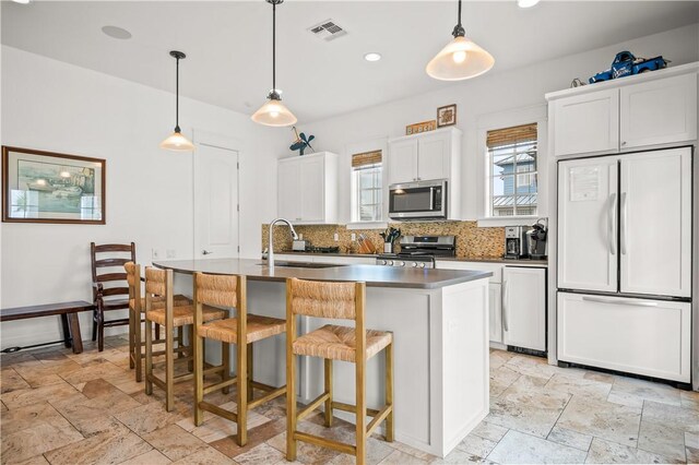 104 Still Water Dr, Port Aransas, TX 78373 - kitchen with stainless steel appliances, stone tile flooring, a sink, tasteful backsplash, and recessed lighting