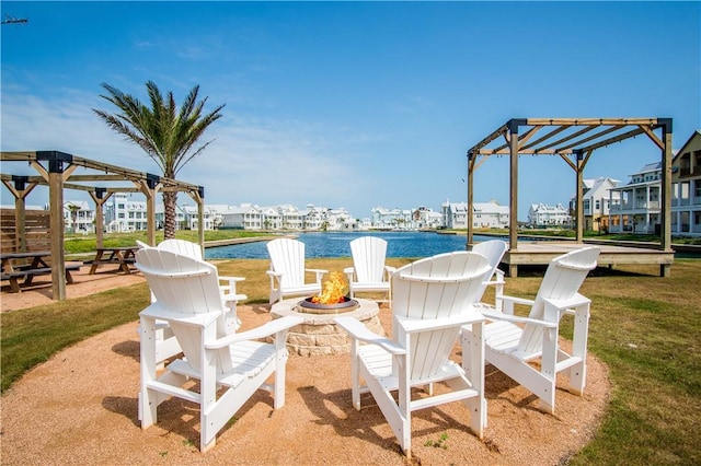 view of patio with a pergola, a water view, and an outdoor fire pit