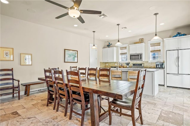 dining space with ceiling fan and sink