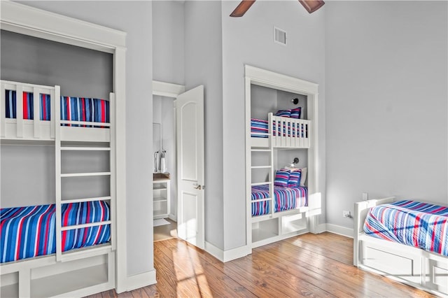 bedroom featuring a high ceiling, hardwood / wood-style flooring, and ceiling fan