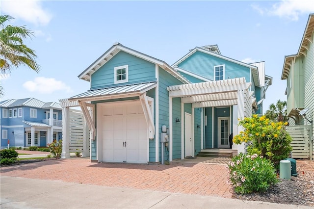 104 Still Water Dr, Port Aransas, TX 78373 - view of front of home featuring decorative driveway, metal roof, a standing seam roof, a garage, and a pergola