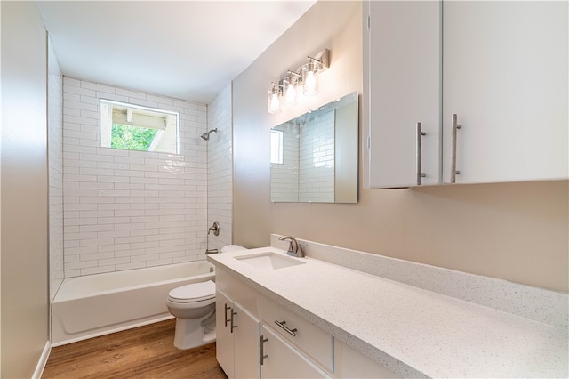 full bathroom with hardwood / wood-style flooring, vanity, toilet, and tiled shower / bath combo