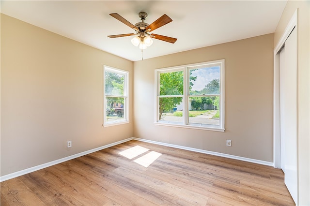 unfurnished bedroom featuring ceiling fan, a closet, and light wood-type flooring