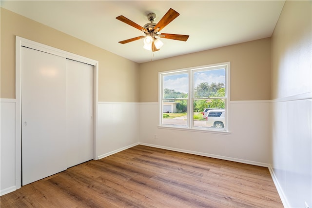 unfurnished bedroom featuring light wood-type flooring, ceiling fan, and a closet