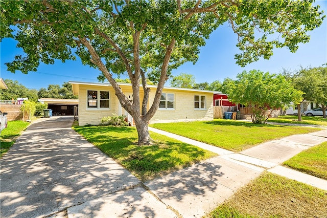 ranch-style home featuring a carport and a front lawn