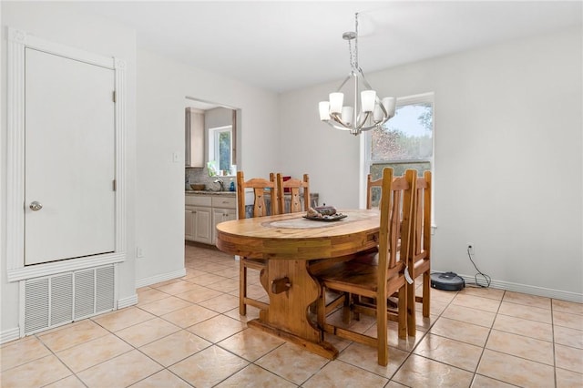 tiled dining room featuring a chandelier