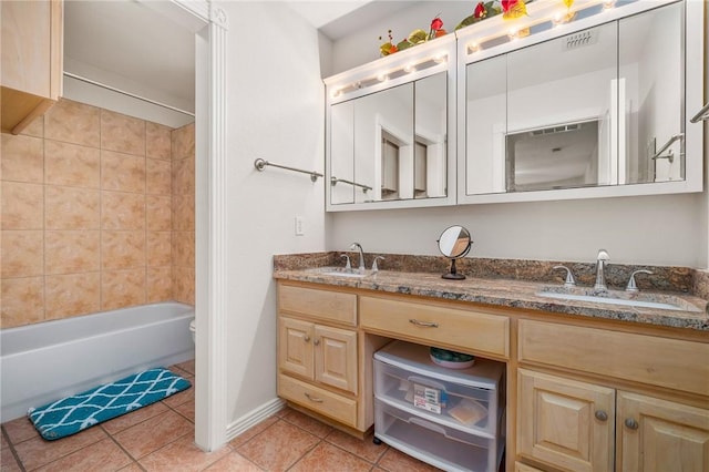 full bathroom featuring tile patterned flooring, vanity, tiled shower / bath combo, and toilet