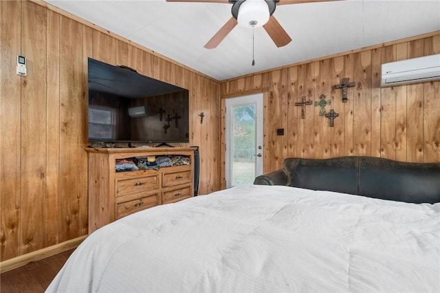 bedroom featuring wood-type flooring, wooden walls, a wall unit AC, and access to outside