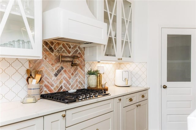 14933 Lake Mead, Robstown, TX 78380 - kitchen with custom exhaust hood, stainless steel gas cooktop, white cabinets, and tasteful backsplash