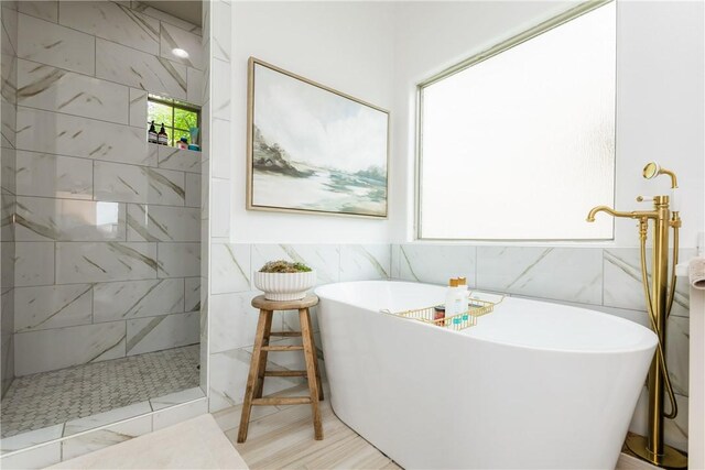 14933 Lake Mead, Robstown, TX 78380 - bathroom featuring tile walls, a walk in shower, and a freestanding bath