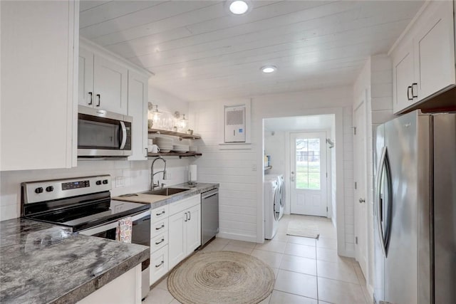 4034 Laguna Shores Rd, Corpus Christi, TX 78418 - kitchen featuring a sink, appliances with stainless steel finishes, washing machine and dryer, and white cabinets