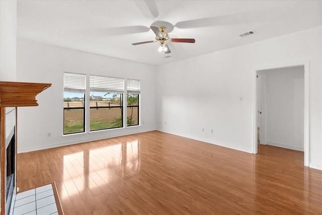 unfurnished living room featuring ceiling fan and light hardwood / wood-style flooring