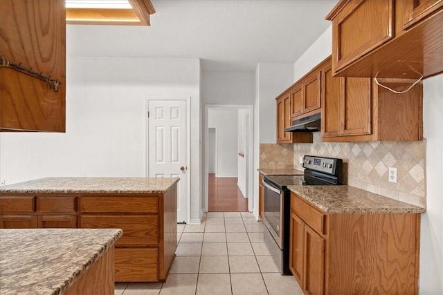 kitchen featuring light tile patterned flooring, decorative backsplash, light stone counters, and electric stove