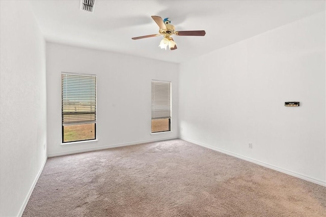 carpeted spare room featuring ceiling fan