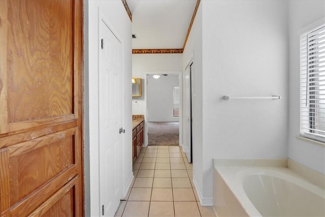 bathroom with tile patterned flooring, vanity, and a washtub