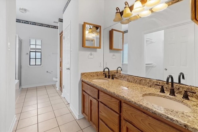 bathroom featuring tile patterned floors, vanity, toilet, and a shower with shower door