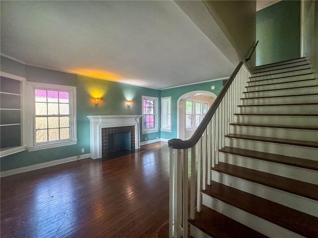 stairs with a tile fireplace and hardwood / wood-style flooring