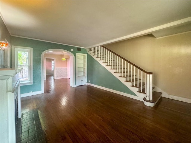 unfurnished living room featuring dark hardwood / wood-style flooring, built in features, and ornamental molding