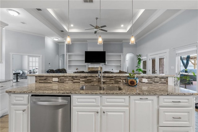 kitchen with white cabinetry, stainless steel dishwasher, a tray ceiling, and sink