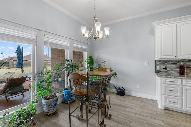 dining room with ornamental molding and a notable chandelier