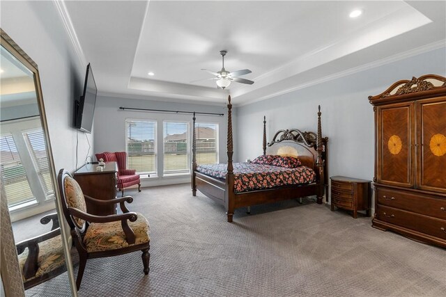 carpeted bedroom featuring a tray ceiling, ornamental molding, and ceiling fan