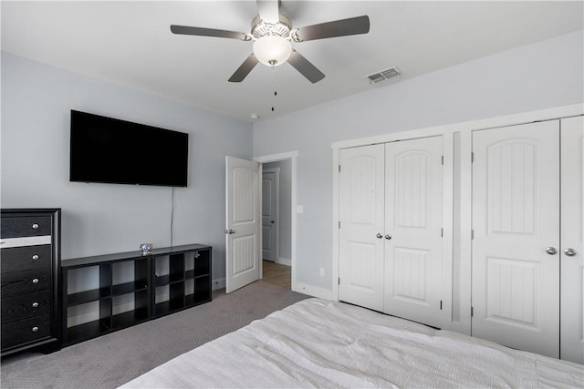 carpeted bedroom featuring multiple closets and ceiling fan