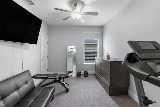 exercise room with light colored carpet and ceiling fan