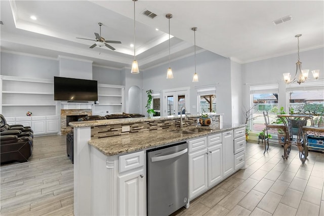 kitchen featuring white cabinetry, decorative light fixtures, a raised ceiling, and dishwasher