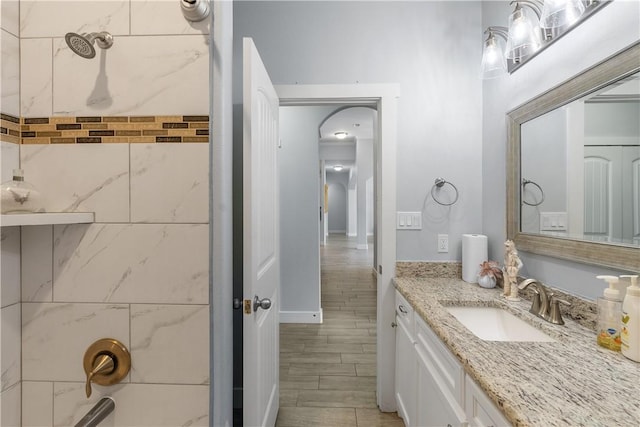 bathroom featuring tiled shower / bath and vanity