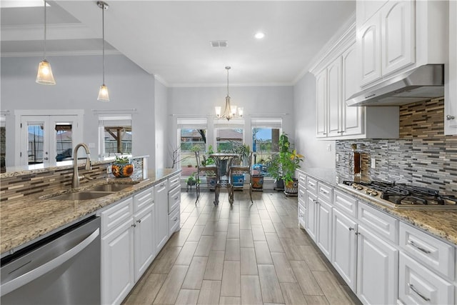 kitchen featuring appliances with stainless steel finishes, sink, white cabinets, crown molding, and light stone countertops