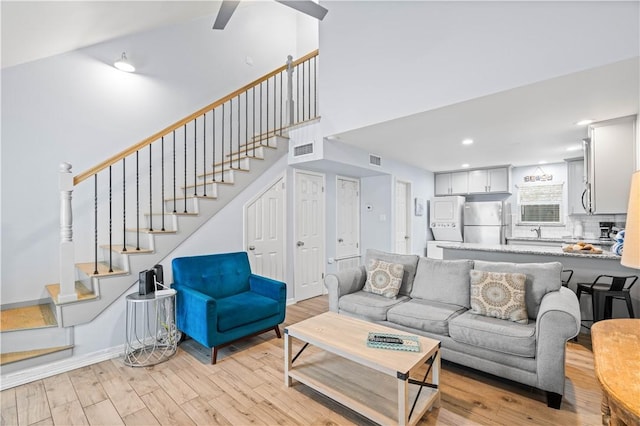 living room with washer / dryer and light hardwood / wood-style floors