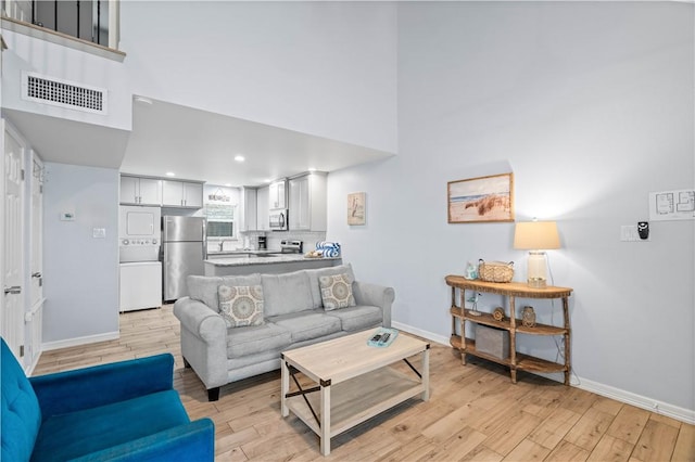 living room featuring a high ceiling and light wood-type flooring