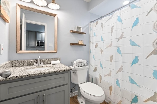 bathroom featuring vanity, hardwood / wood-style floors, curtained shower, and toilet