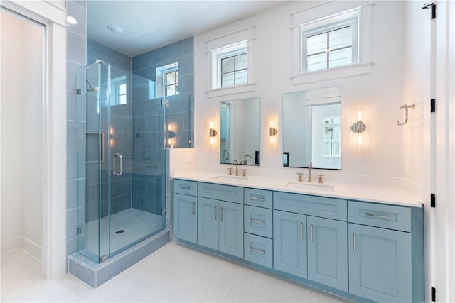 bathroom featuring a shower with door and vanity